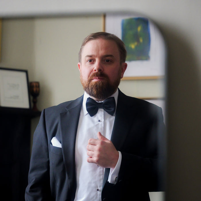 White linen pocket square folded in a black dinner jacket