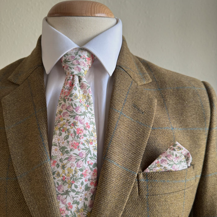 Brown tweed suit with a white shirt, floral tie, and matching pocket square by the belfast bow company