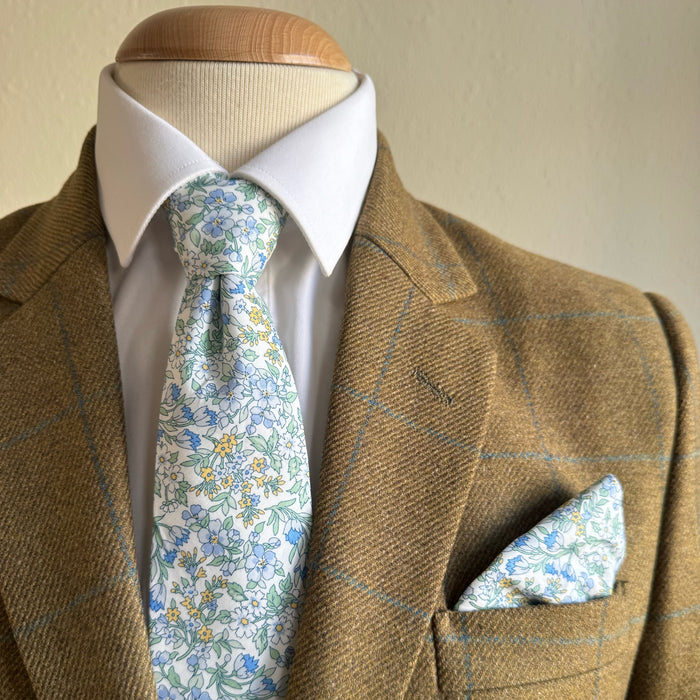 Brown suit with white shirt, floral tie, and matching pocket square by the belfast bow company
