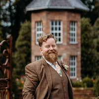 Groom in tweed suit wearing an autumn floral tie by the belfast bow company
